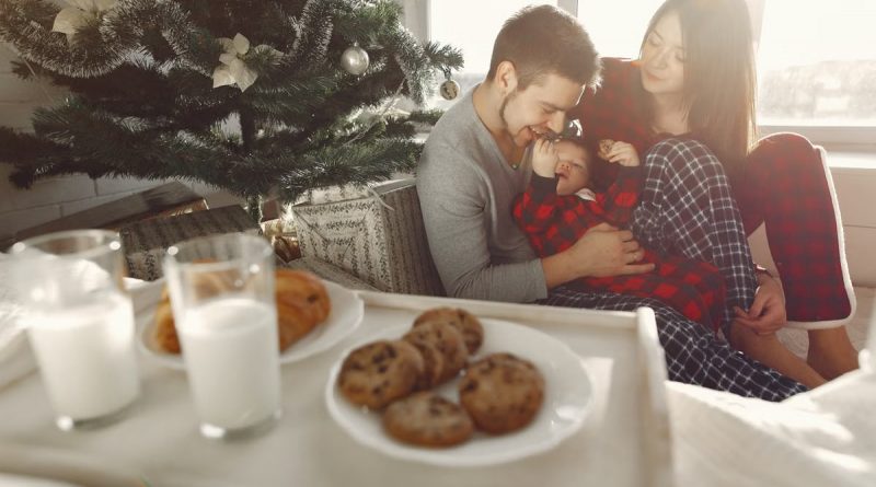 Family enjoying Christmas morning with cookies and milk by the tree.